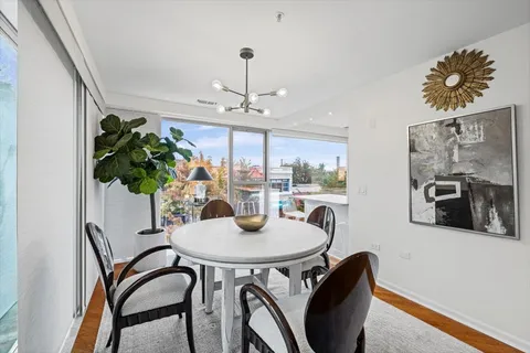 a dining room with furniture potted plants and wooden floor