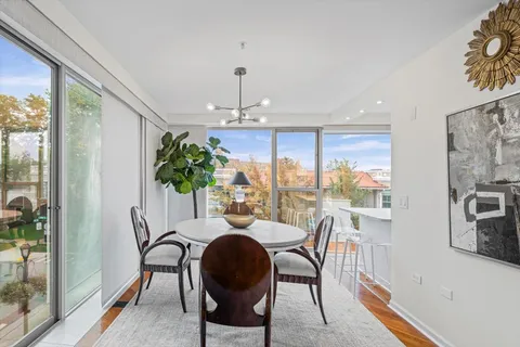a dining room with furniture a chandelier and wooden floor