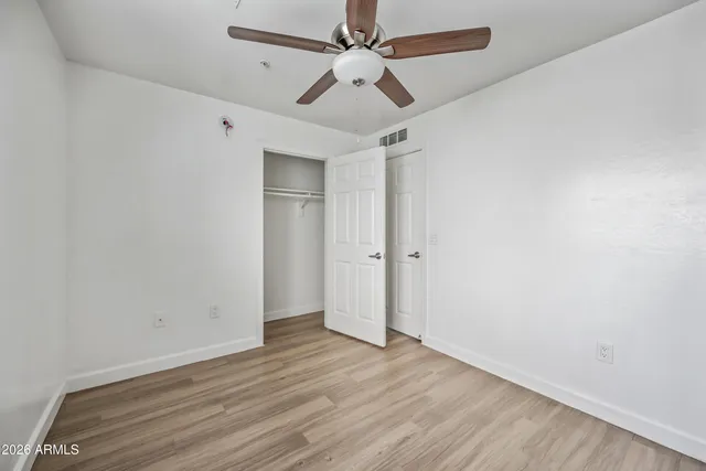 an empty room with a window and a ceiling fan