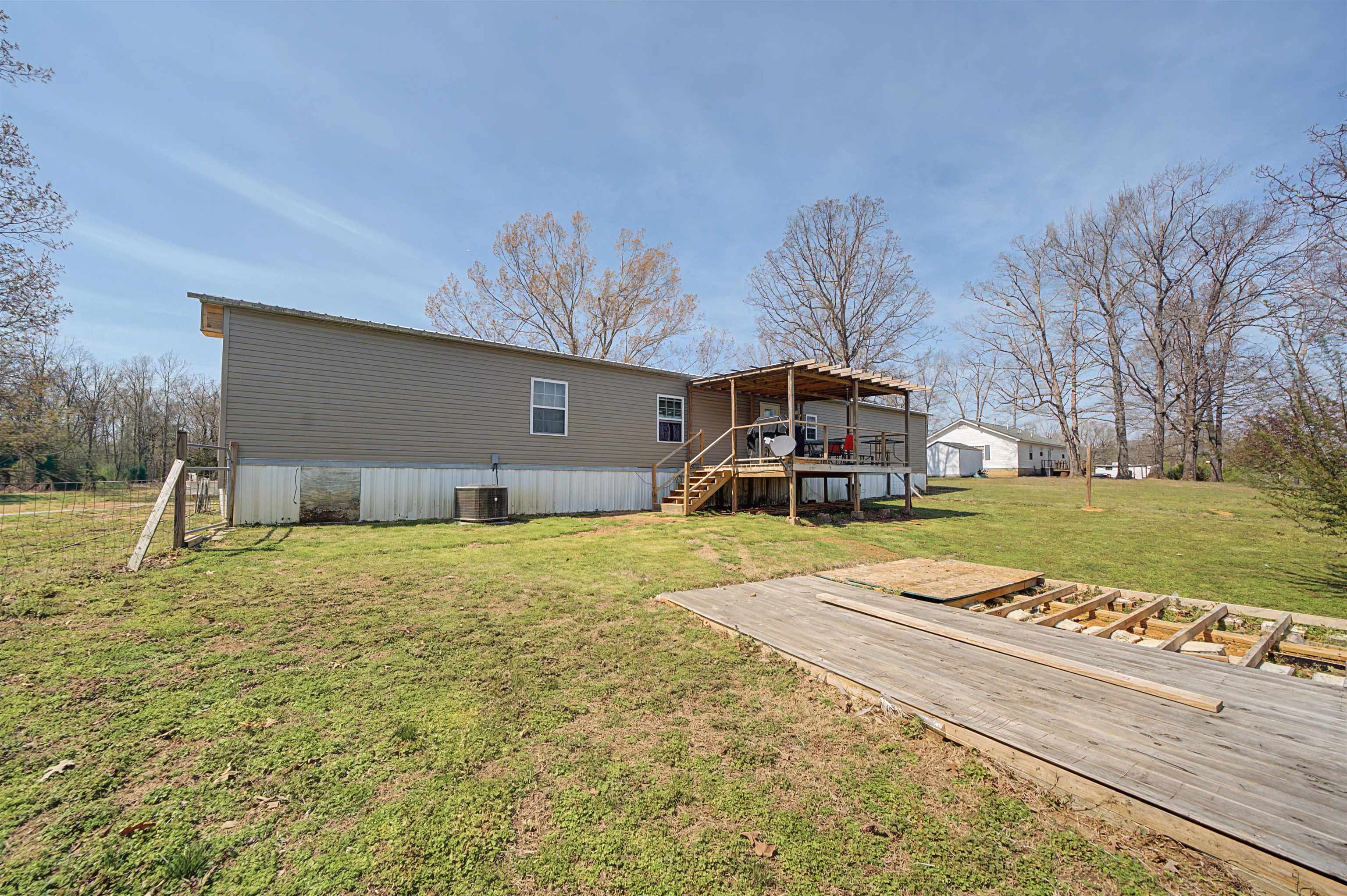7010 22nd Highway Adamsville, TN 38310 - Photo 20 of 33 Back of property with a deck and a lawn