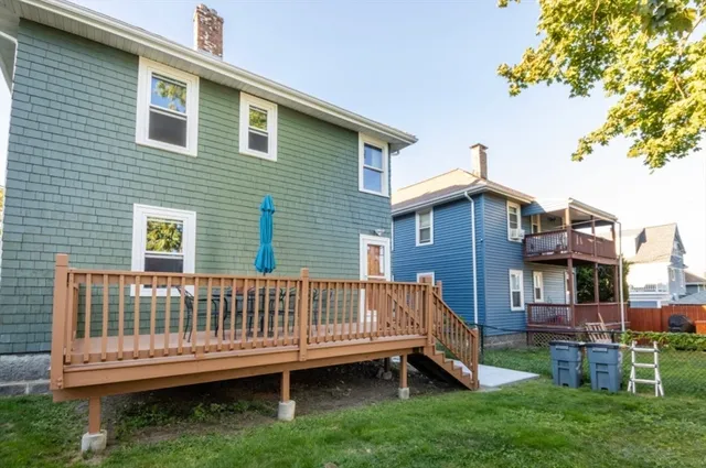 a view of a house with a yard and deck
