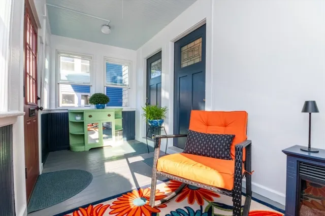 a living room with furniture a lamp and large window