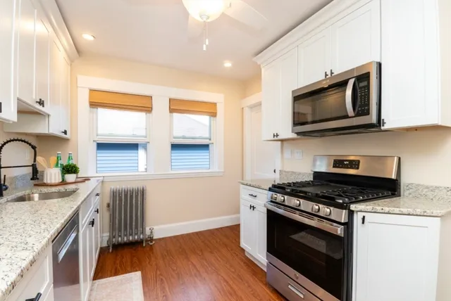 a kitchen with granite countertop a sink cabinets and stainless steel appliances