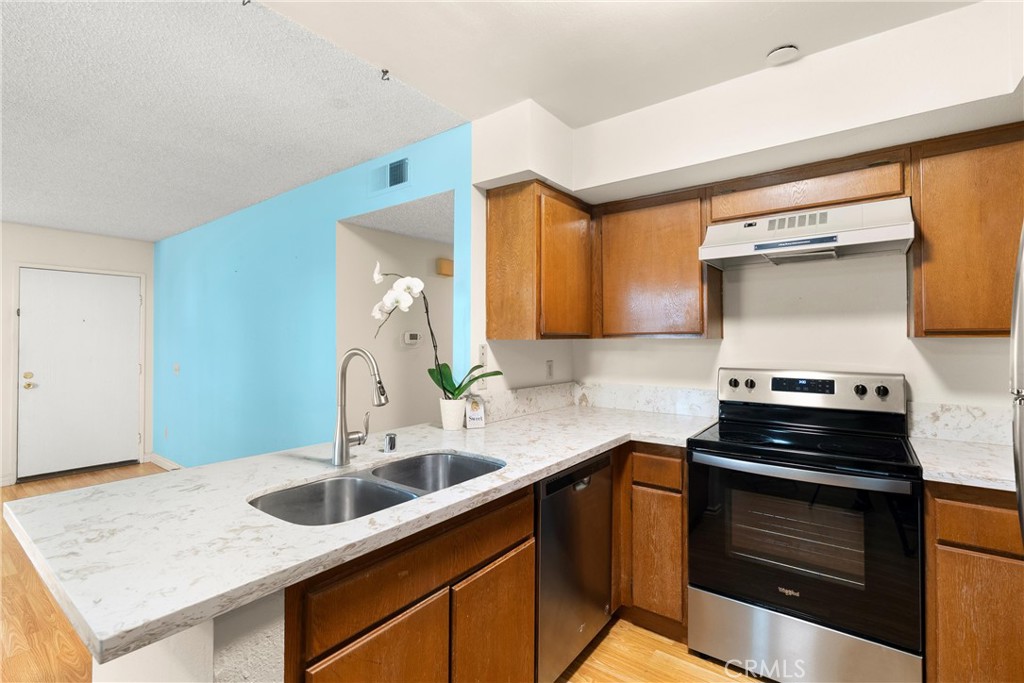 12621 Moordale Circle, Unit G Stanton, CA 90680 - Photo 13 of 36 a kitchen with a sink cabinets and wooden floor