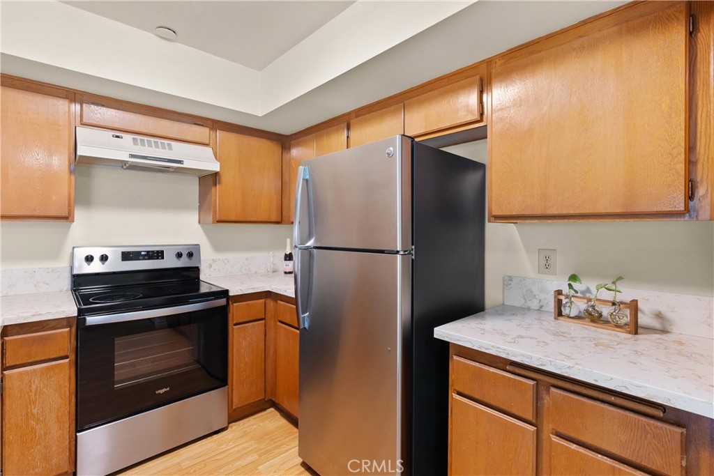 12621 Moordale Circle, Unit G Stanton, CA 90680 - Photo 15 of 36 a kitchen with a refrigerator and a stove top oven