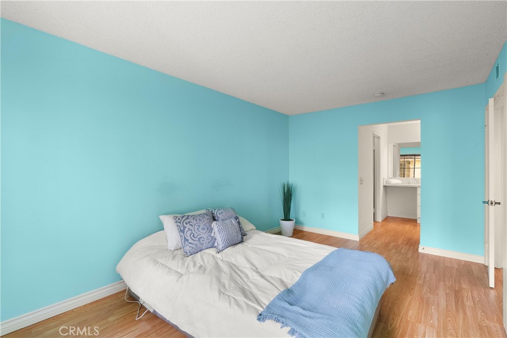 12621 Moordale Circle, Unit G Stanton, CA 90680 - Photo 21 of 36 a bedroom with a bed and a wall painting
