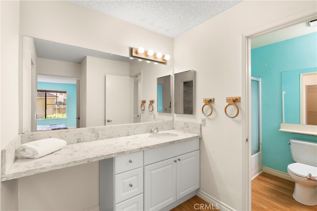 12621 Moordale Circle, Unit G Stanton, CA 90680 - Photo 23 of 36 a bathroom with a granite countertop sink mirror vanity and toilet
