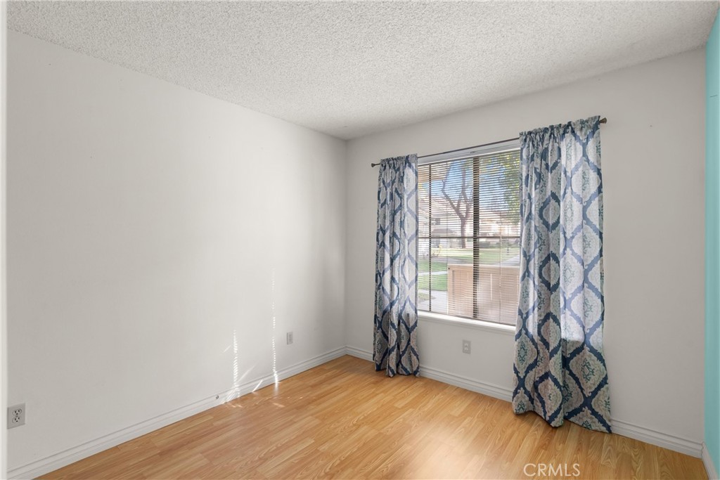 12621 Moordale Circle, Unit G Stanton, CA 90680 - Photo 26 of 36 a view of an empty room with a window and hardwood floor