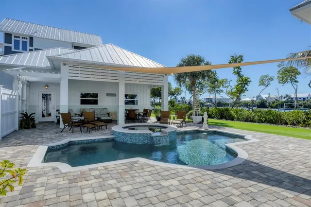 a living room with furniture kitchen view and a chandelier
