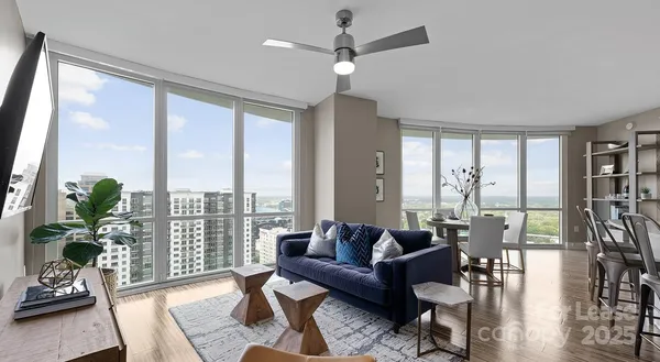 a living room with furniture and a large window with wooden floor