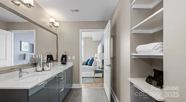 a en suite bathroom with a granite countertop sink and a mirror