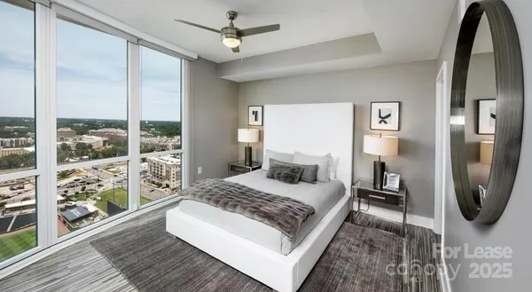 a bedroom with a bed a mirror and windows