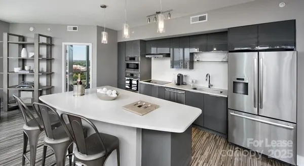 a kitchen with stainless steel appliances a table chairs and refrigerator