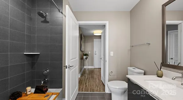 a bathroom with a granite countertop sink a toilet and shower