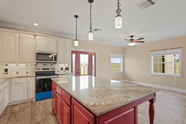 a kitchen with stainless steel appliances granite countertop a kitchen island a stove and a sink