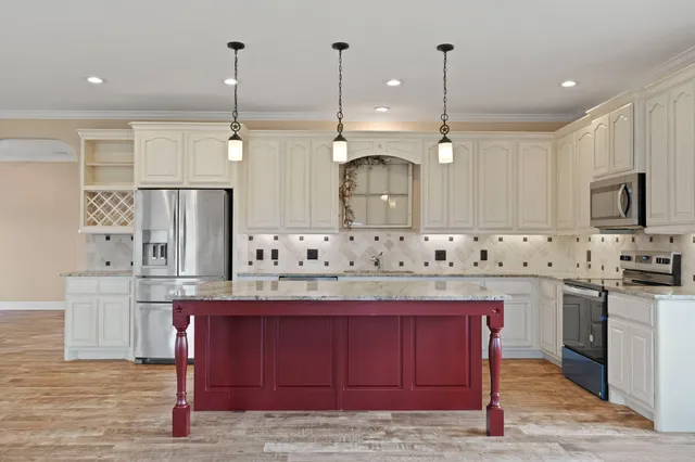 a kitchen with kitchen island granite countertop a sink stove and refrigerator