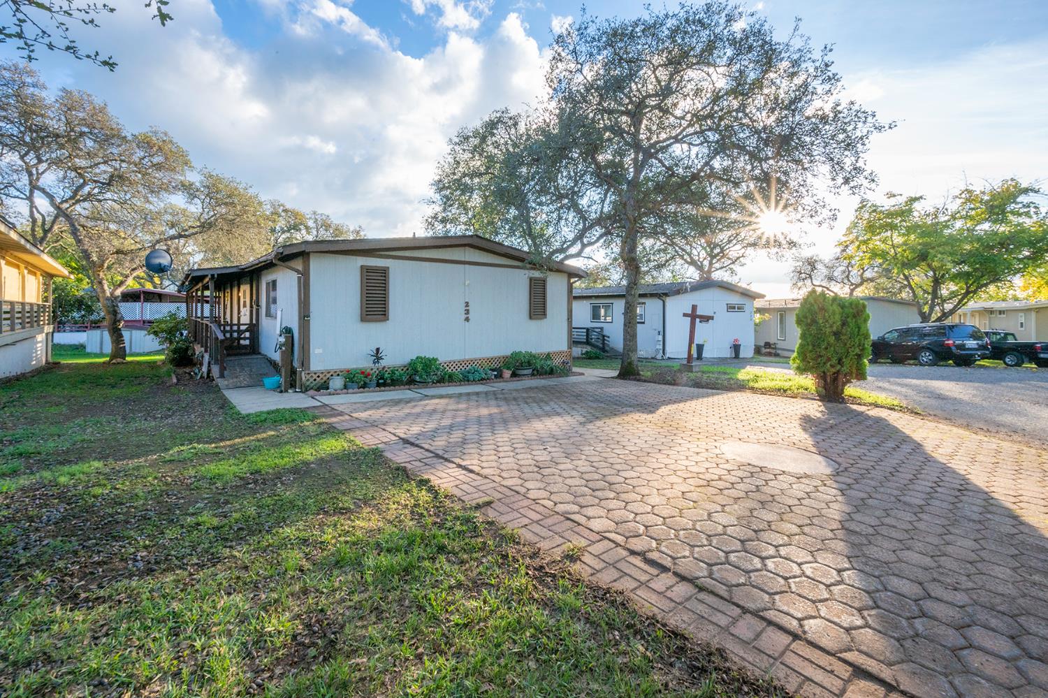 a view of a white house with a yard and large tree
