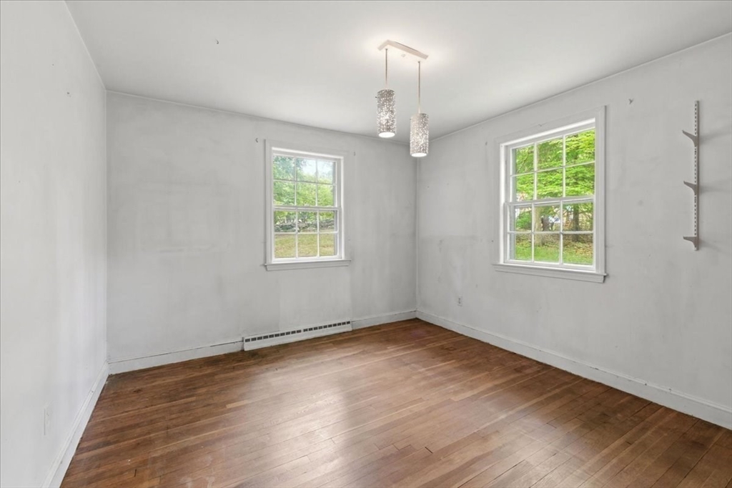 99 Brook Road Sharon, MA 02067 - Photo 16 of 37 an empty room with wooden floor chandelier and windows