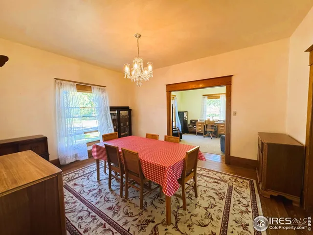 a dining room with furniture a rug a fireplace and a chandelier