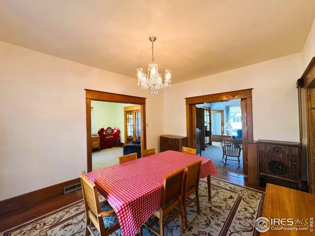 a view of a dining room with furniture a chandelier and wooden floor