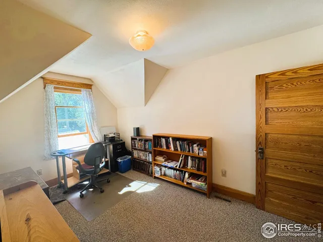 a view of a workspace with furniture and a window