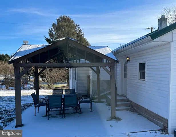 a view of a patio with table and chairs with wooden floor and fence