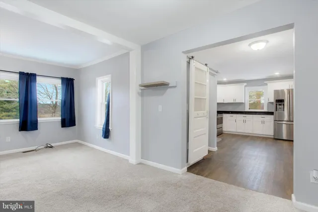 a view of a kitchen with refrigerator and windows