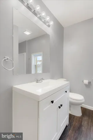 a bathroom with a sink a toilet a mirror and vanity