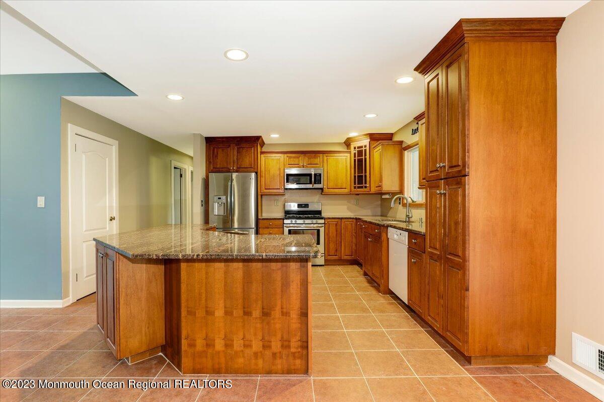 56 Wyckham Road Tinton Falls, NJ 07724 - Photo 20 of 40 a kitchen with stainless steel appliances granite countertop a refrigerator and a stove