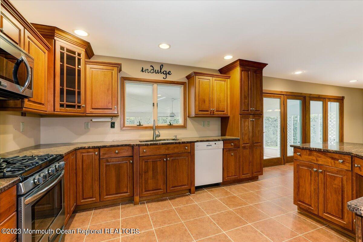 56 Wyckham Road Tinton Falls, NJ 07724 - Photo 24 of 40 a kitchen with stainless steel appliances granite countertop a stove a sink and a microwave
