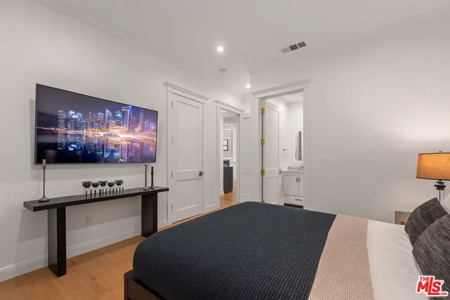 a bedroom with a bed and a flat screen tv