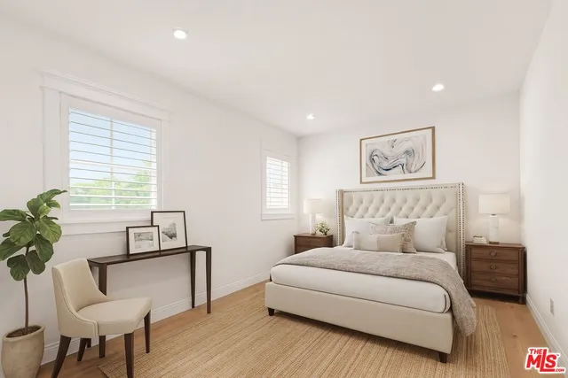 a bedroom with a large bed and a potted plant