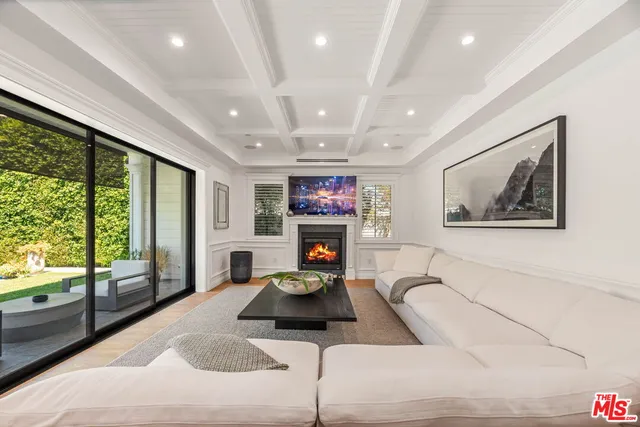 a living room with furniture large window and a fireplace