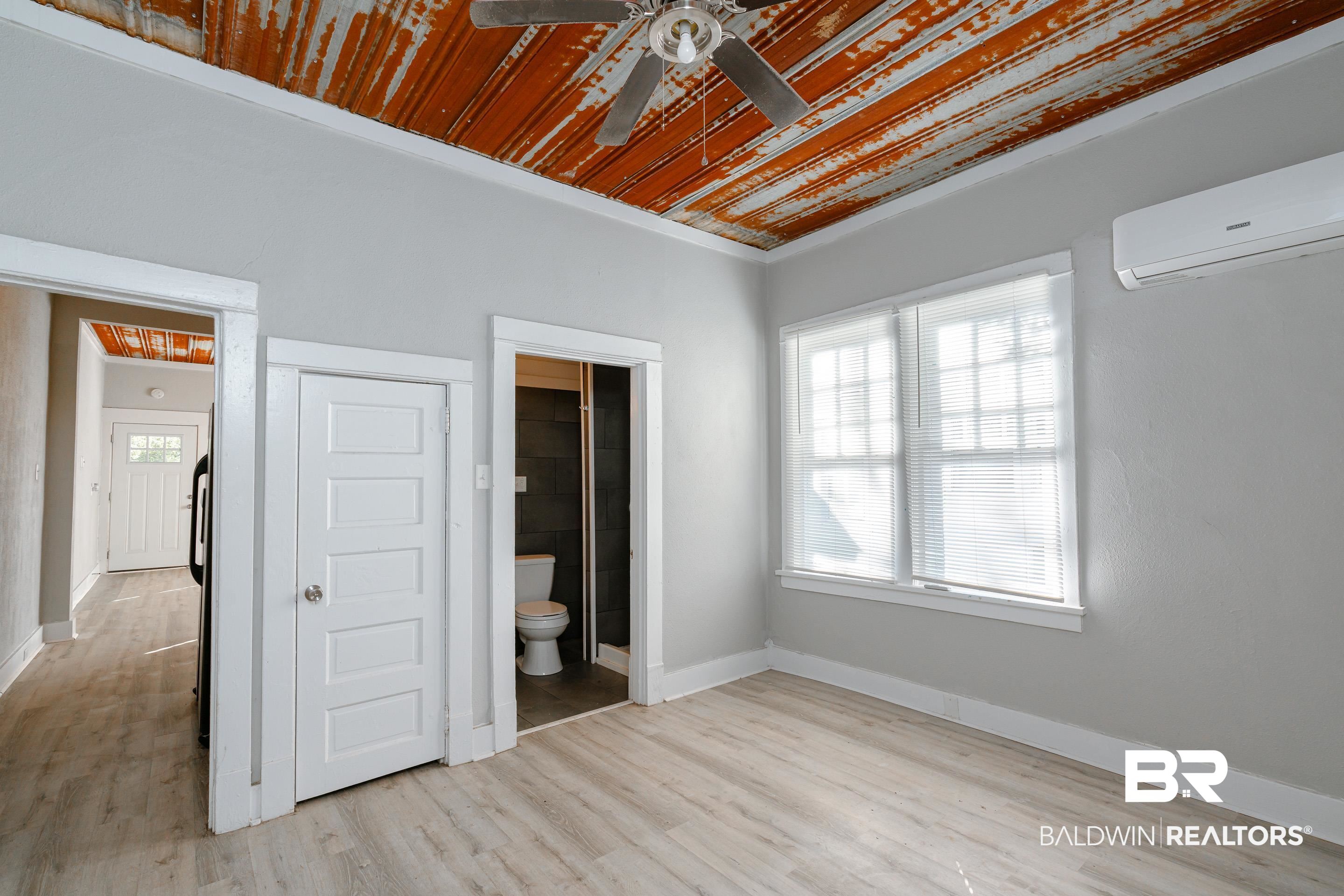 5 North Fulton Street Mobile, AL 36607 - Photo 47 of 55 Unfurnished bedroom featuring wood ceiling, ceiling fan, a wall mounted air conditioner, ensuite bath, and light hardwood / wood-style flooring