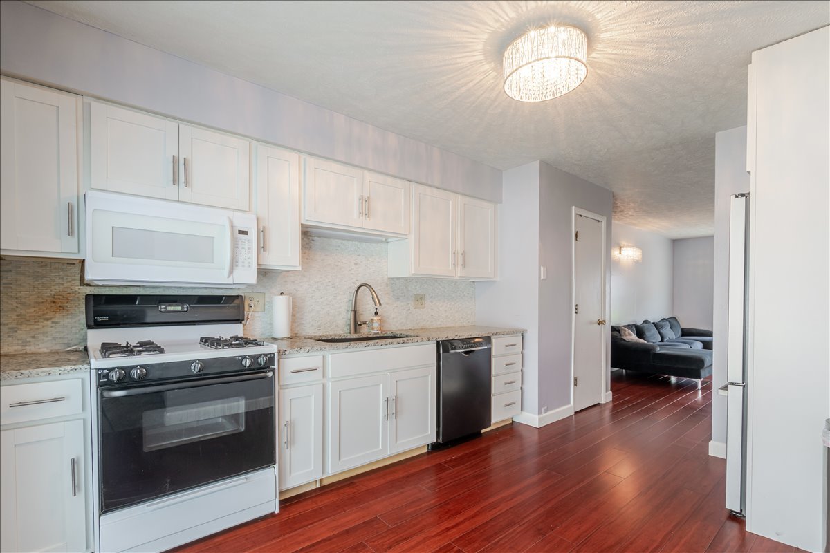 103 South Towanda Avenue, Unit 3 Normal, IL 61761 - Photo 7 of 17 a kitchen with a stove cabinets and wooden floor