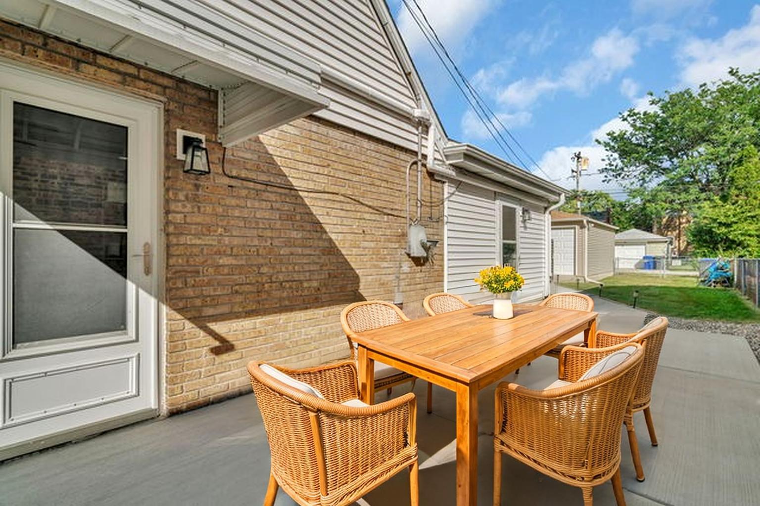 4239 Custer Avenue Lyons, IL 60534 - Photo 24 of 27 a backyard of a house with wooden floor chairs and a fire pit