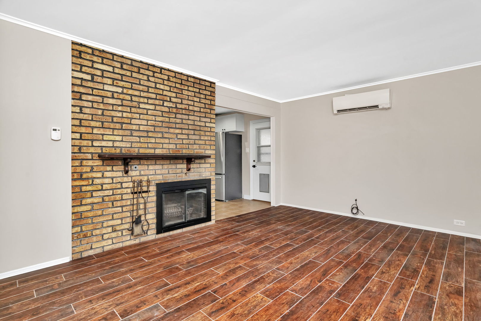 4239 Custer Avenue Lyons, IL 60534 - Photo 3 of 27 a view of empty room with wooden floor and fireplace