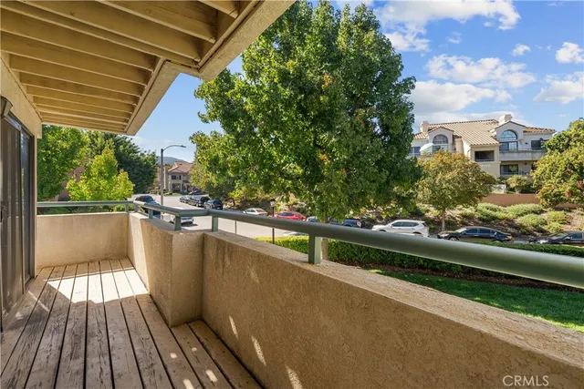 a view of balcony with wooden floor and fence