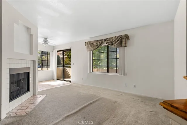 an empty room with windows and fireplace