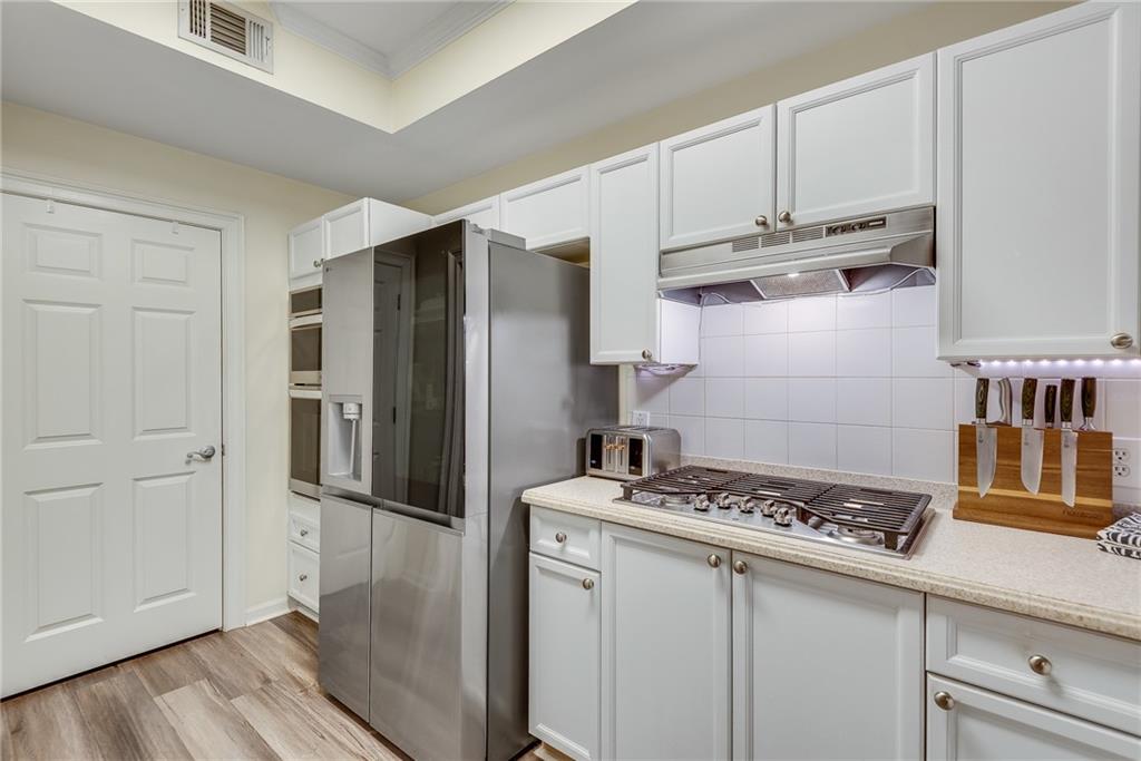 3275 Lenox Road Northeast, Unit 108 Atlanta, GA 30324 - Photo 4 of 22 a kitchen with stainless steel appliances granite countertop a refrigerator and a stove top oven