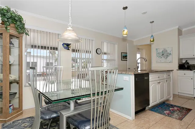 a kitchen with stainless steel appliances granite countertop a refrigerator a sink dishwasher a dining table and chairs with wooden floor