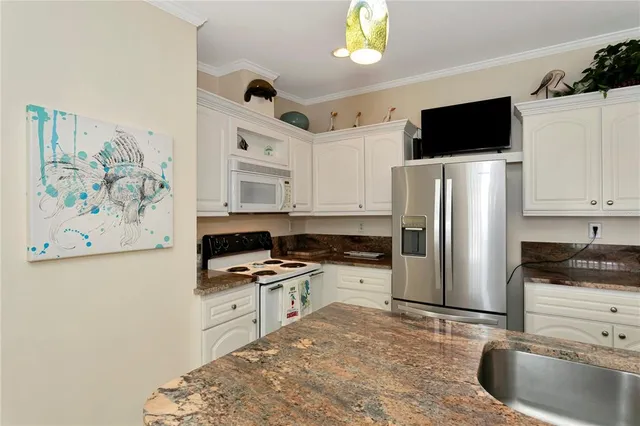 a kitchen with stainless steel appliances a refrigerator a stove a sink and a counter space