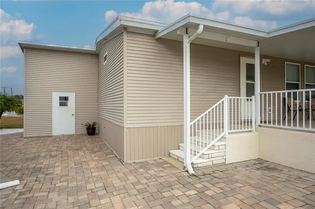a view of a house with a small yard and wooden floor and fence