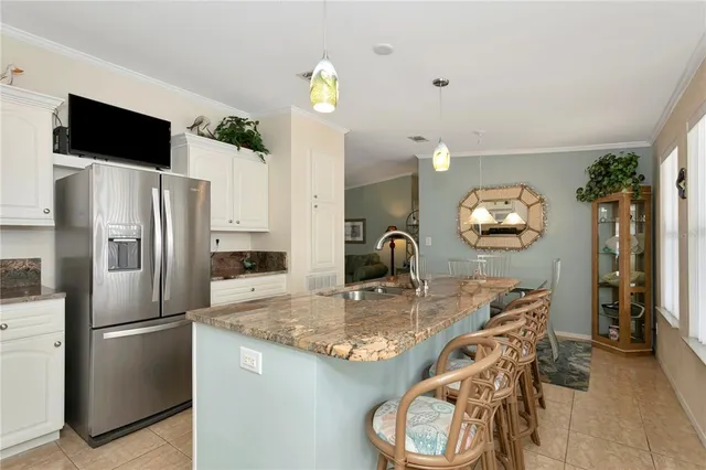 a kitchen with stainless steel appliances granite countertop a sink a refrigerator and a wooden floor
