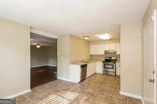 a kitchen with granite countertop a refrigerator and a stove top oven
