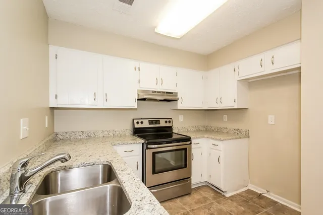 a kitchen with white cabinets sink and stainless steel appliances