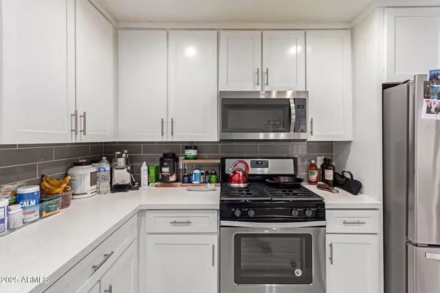 a kitchen with stainless steel appliances granite countertop a stove a microwave and cabinets