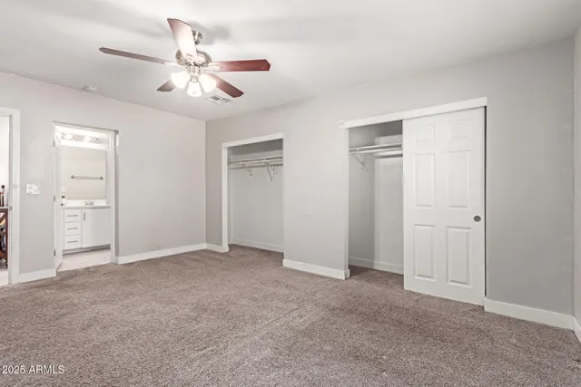 a view of an empty room with a chandelier fan