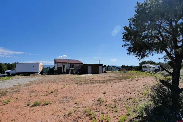 a view of a dirt road with a building in the background