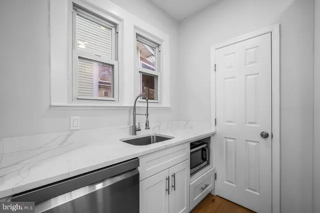 a kitchen with stainless steel appliances white cabinets and a window